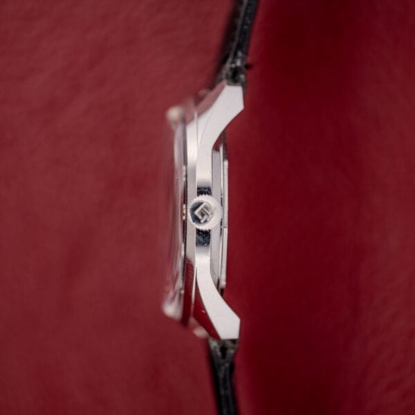 Tissot Seastar Ref. 42568 with a matte black dial and black leather strap, stainless steel case (Cal. 781-1), shown from the side against a red background.