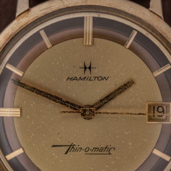 Close-up of a Hamilton Thin-O-Matic Brown & Gold Dial Automatic Cal. 624 watch, featuring aged hands and the date set to the 19th.
