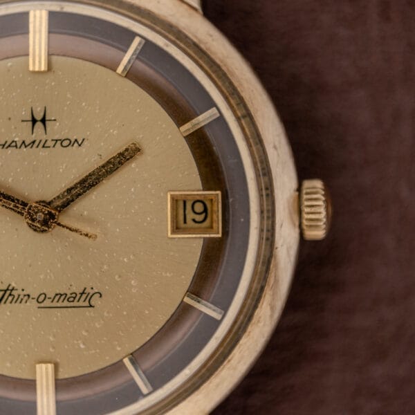 Close-up of the Hamilton Thin-O-Matic Brown & Gold Dial, featuring Automatic Cal. 624 movement, gold hands, and a date display set to 19.