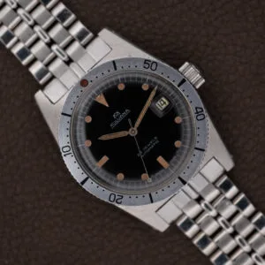 A Silvana 25 Jewels Automatic Skin Diver with Cal. 2472 movement, featuring a black dial and date display, is presented on a metal bracelet atop a brown surface.