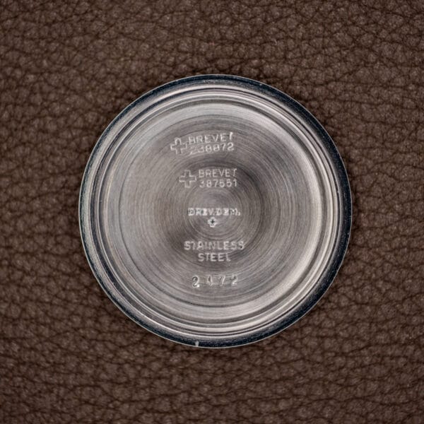 Round stainless steel case back with engraved patent numbers from the Silvana 25 Jewels Automatic Skin Diver Cal. 2472 Black Dial, shown on a brown textured background.