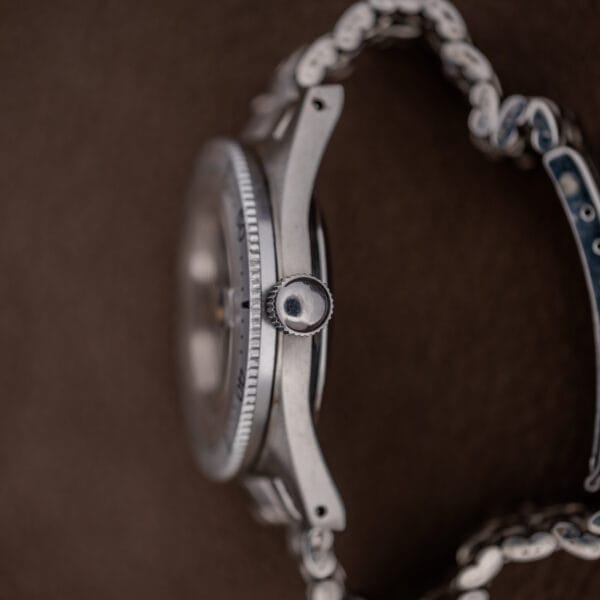 Side view of the Silvana 25 Jewels Automatic Skin Diver Cal. 2472 Black Dial, highlighting its metal band, crown, and case against a brown background.