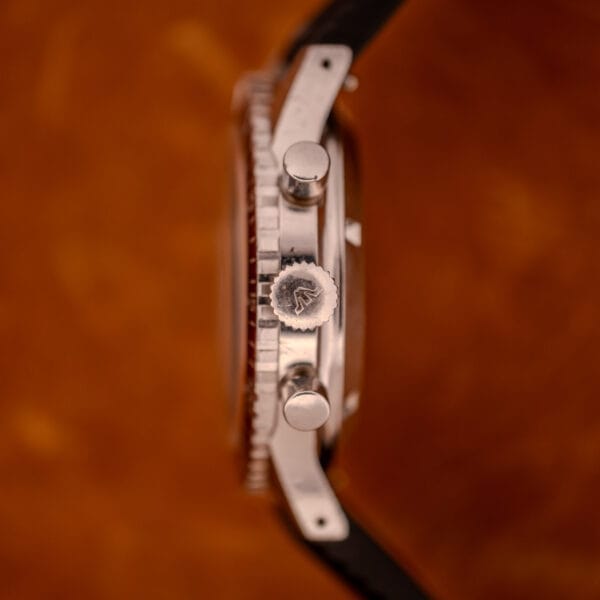 Side view of the Wittnauer Professional Chronograph Ref. 7004 Landeron 248, showing its crown and two pushers against a brown background.