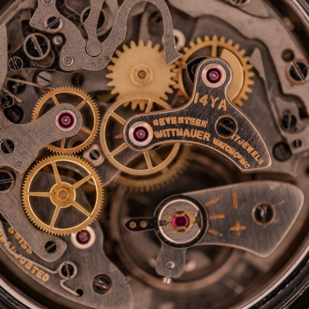 Close-up of intricate gears and engraved metal parts inside the Wittnauer Professional Chronograph Ref. 7004 Landeron 248, showcasing its detailed vintage watch mechanisms.