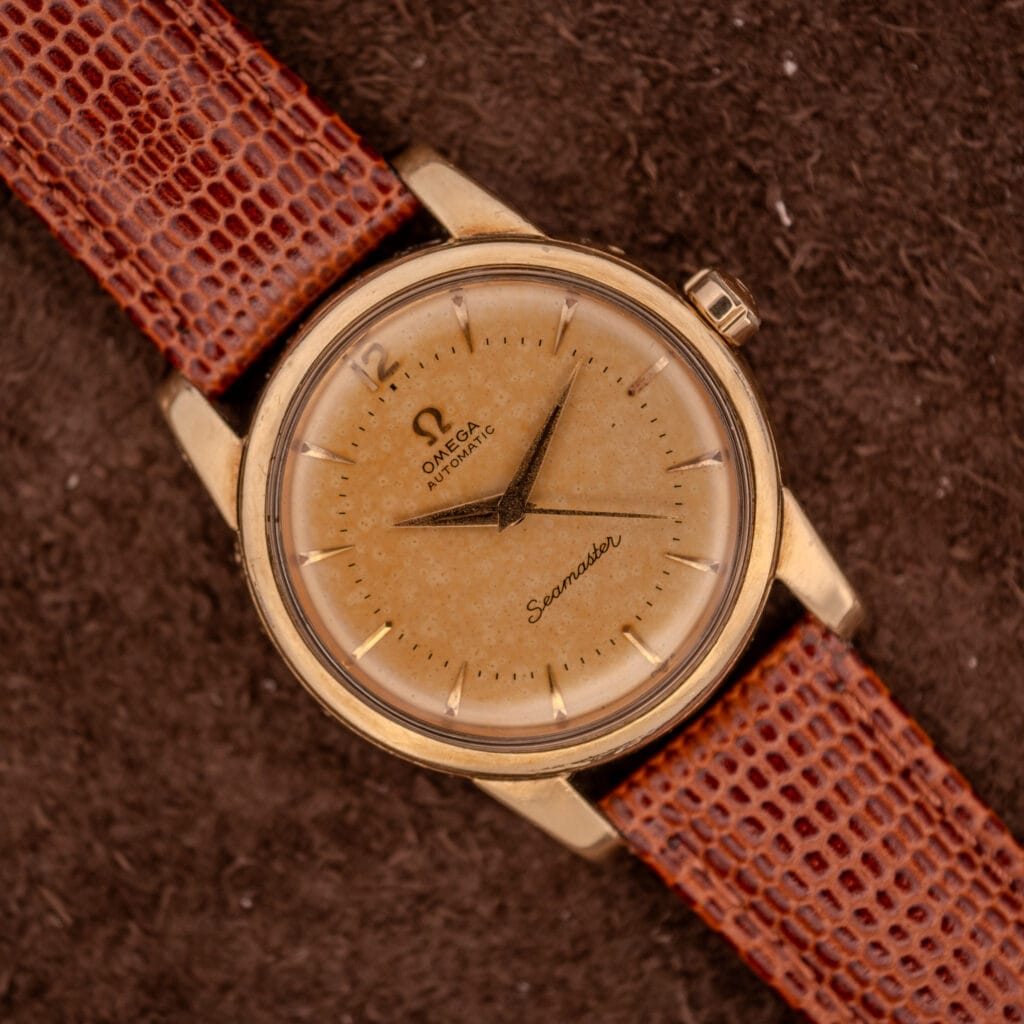 An Omega Seamaster Automatic Ref. 2848-2849 with Cal. 500 movement, featuring a brown leather strap and displayed on a textured brown background.