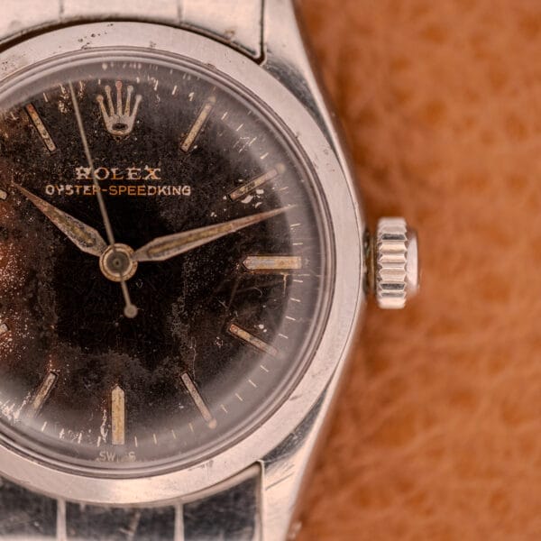 Close-up of a vintage Rolex Oyster Speedking Ref. 6420 Stainless Steel Black Dial watch, showcasing a worn black dial and sturdy stainless steel case.