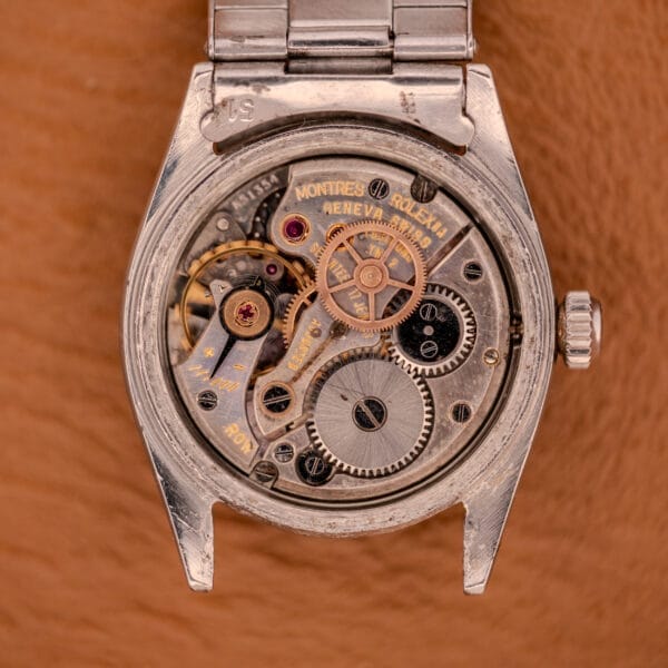 Close-up of the Rolex Oyster Speedking Ref. 6420 Stainless Steel Black Dial, with its back open to reveal detailed mechanical gears and intricate inner workings.