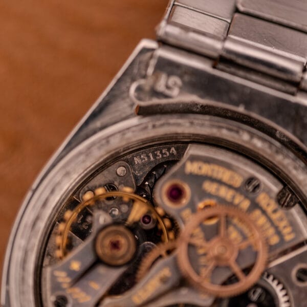 Close-up of the Rolex Oyster Speedking Ref. 6420 Stainless Steel Black Dial, highlighting its intricate inner gears and serial number with detailed stainless steel components.