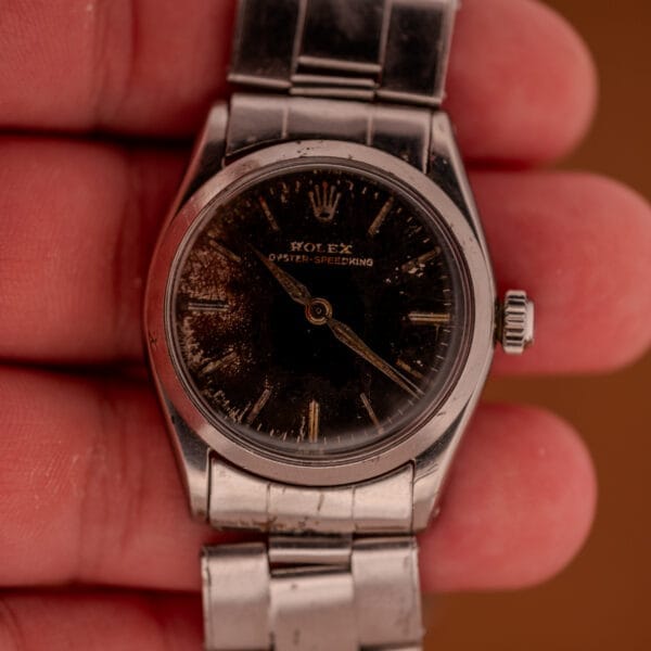 A hand holding a Rolex Oyster Speedking Ref. 6420 Stainless Steel Black Dial, featuring vintage details and classic style.