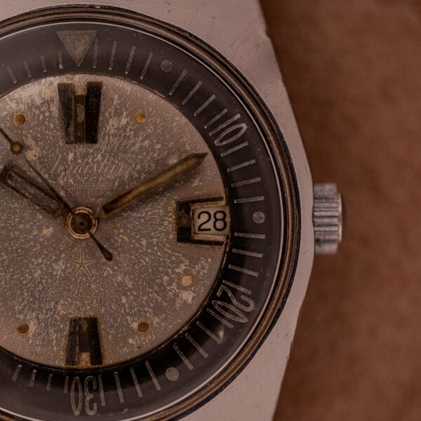 Close-up of a vintage Aquastar 1701 Skin Diver 200 Meters Automatic with a Tropic Rubber Strap, date set to 28, showing visible scratches and discoloration.