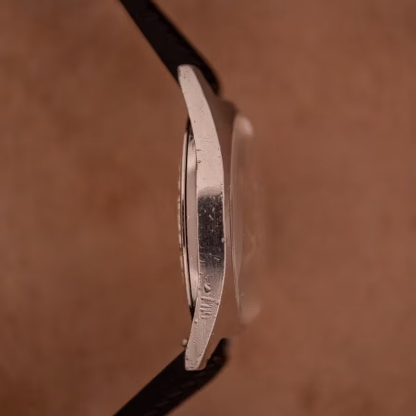 Opposite side profile of Aquastar 1701 stainless steel case, angular flared lugs, and visible tool marks consistent with past servicing.