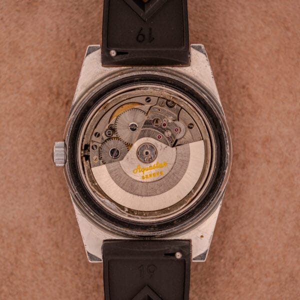 Back of the Aquastar 1701 Skin Diver 200 Meters Automatic, showcasing its exposed mechanical movement and yellow "Aquastar" and "Swiss" text. Comes with a classic Tropic Rubber Strap, designed for performance and durability.