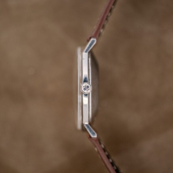 Side view of the Hamilton Automatic Silver Linen Dial Stainless Steel Cal. 689A, featuring a brown leather strap and engraved crown, set against a refined silver linen dial.