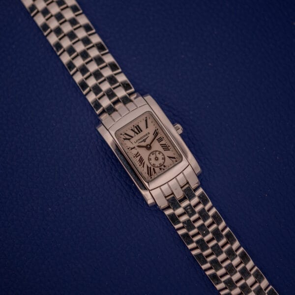 The Longines Dolce Vita L5.155.4 features a polished stainless steel rectangular Tank Case, Roman numerals, and a textured dark blue dial.