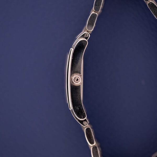 Side view of the Longines Dolce Vita L5.155.4 with a stainless steel tank case, shown on a dark blue background to highlight its slim profile and elegant bracelet.