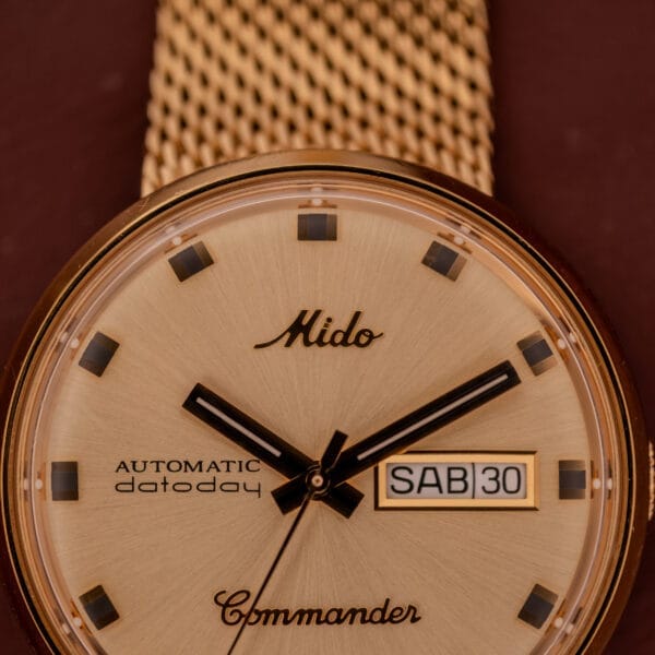 Close-up of the Mido Commander Automatic Datoday Ref. 8429 with a Milanese strap, displaying the day and date as SAB 30.