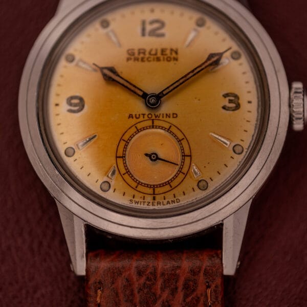 Close-up of a Gruen Precision Auto-Wind Copper Dial Stainless Steel Cal. 400 wristwatch with a brown leather strap.