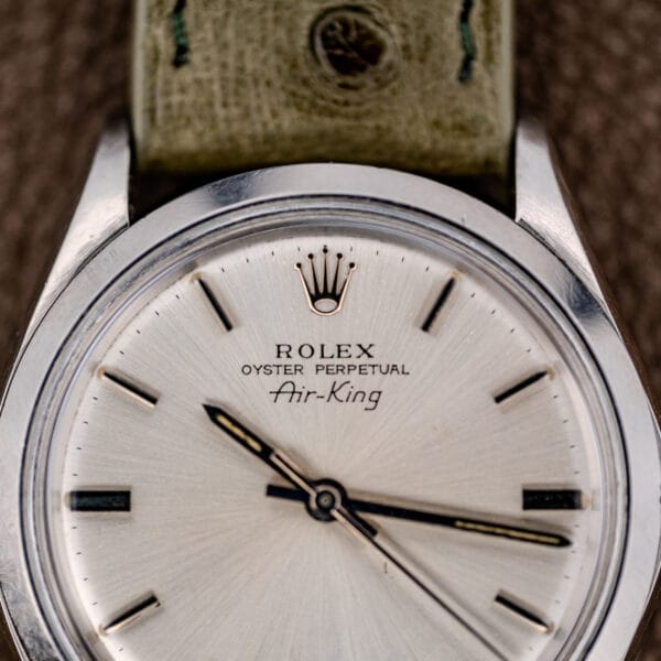 Close-up of a Rolex Oyster Perpetual Air King Ref. 5500 with a Silver Sunburst Dial and leather strap.