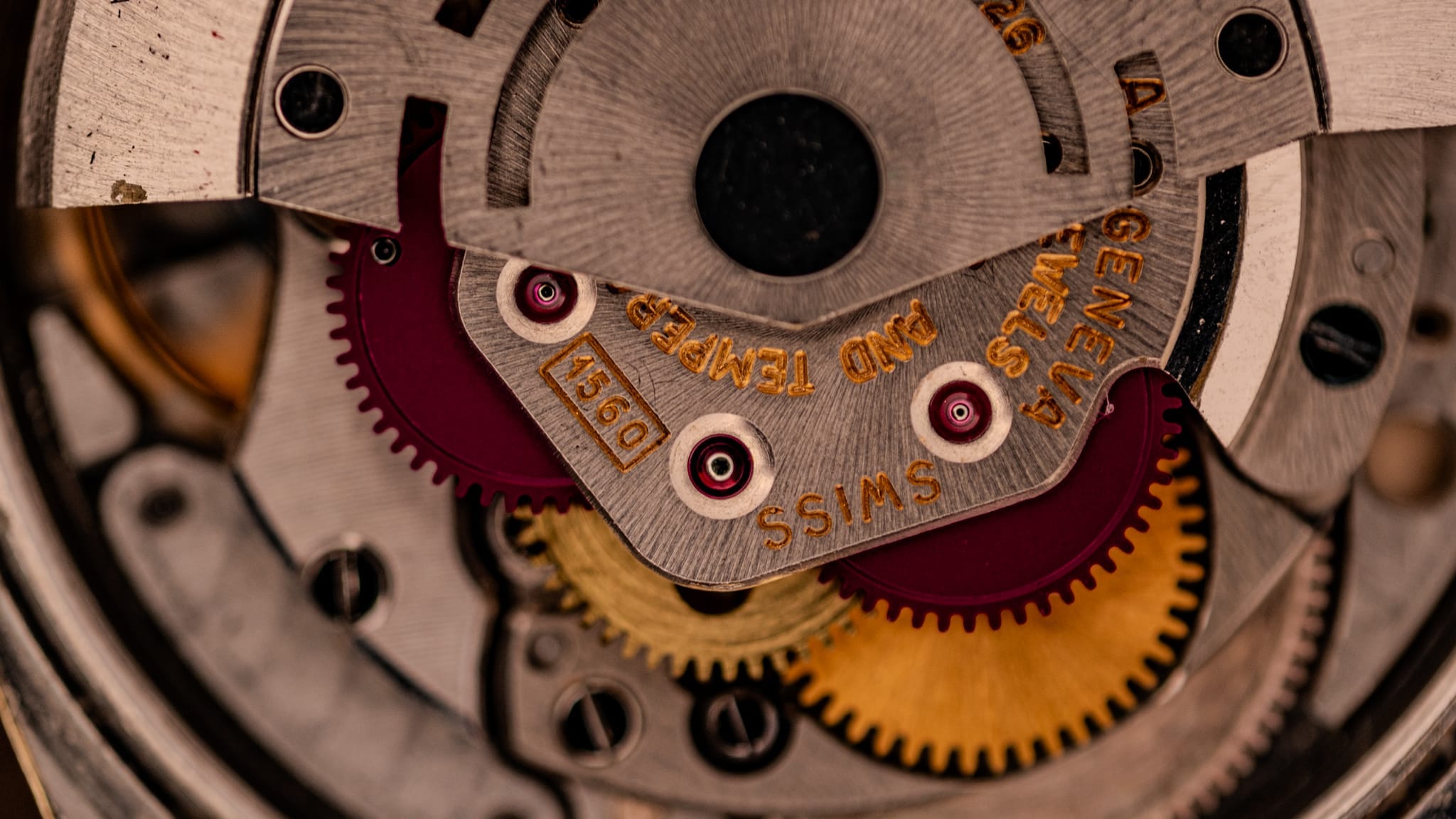 Close-up of Rolex watch gears and mechanical parts, showcasing intricate details and engraved SWISS text—a guide for spotting authentic serial numbers.
