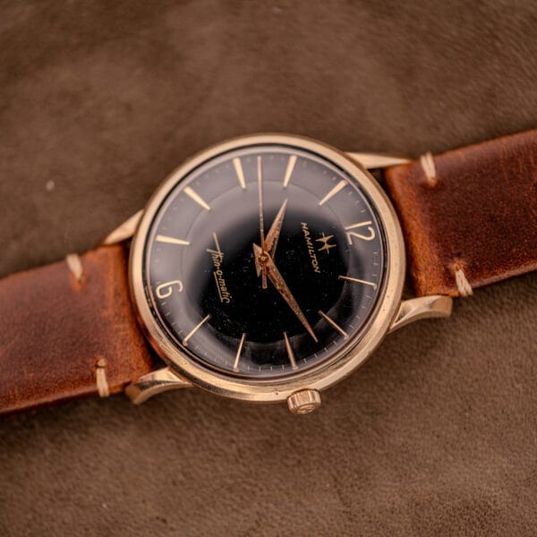 A Hamilton Thin-O-Matic Black Dial watch with a 10k gold filled case (Cal. 663) rests on a brown suede surface.