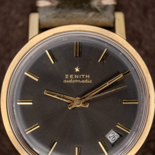 Close-up of a Zenith Automatic Date with charcoal sunburst dial, gold markers, date at 4 o’clock, powered by Cal. 2542 PC.