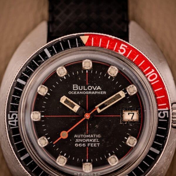Close-up of the Bulova Oceanographer Automatic Snorkel 714 with its Red Cross Hair Dial, showing the hands and date at 3 o’clock—spotlighting this watch’s distinctive and classic design.