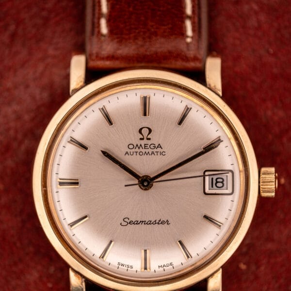 Close-up of an Omega Automatic Seamaster Date Ref. KM 6323, powered by Cal. 563, with a brown leather strap and the date set to the 18th.