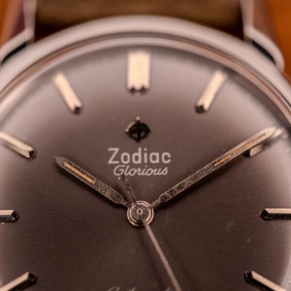 Close-up of a vintage Zodiac Glorious Automatic Ref. 702-917 featuring silver hands and hour markers on a brown dial, all set within a classic stainless steel case and powered by Cal. 70-72.
