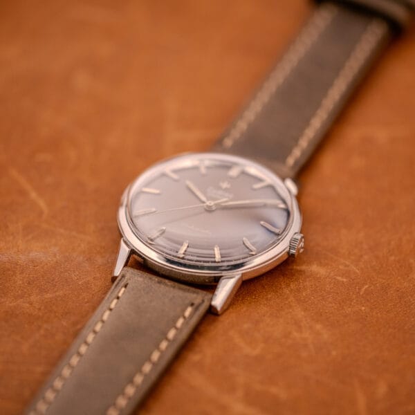 A Zodiac Glorious Automatic Ref. 702-917 Stainless Steel Cal. 70-72 wristwatch with a brown leather strap sits on a brown leather surface, highlighting its classic stainless steel case.