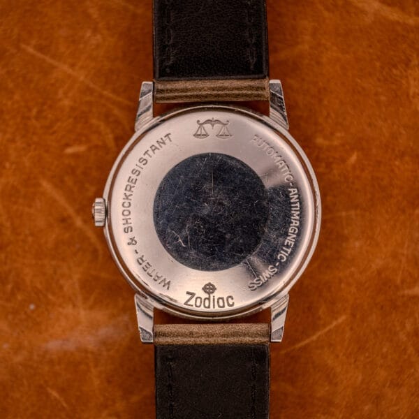 The Zodiac Glorious Automatic Ref. 702-917, featuring a stainless steel case and Cal. 70-72 engravings, rests on brown leather, highlighting its refined craftsmanship.