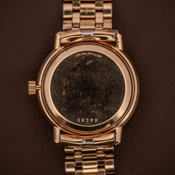 Universal Geneve Polerouter Date with Arabic numerals dial and automatic Cal 215, shown from the back; metal band displays visible scratches and engraved numbers.