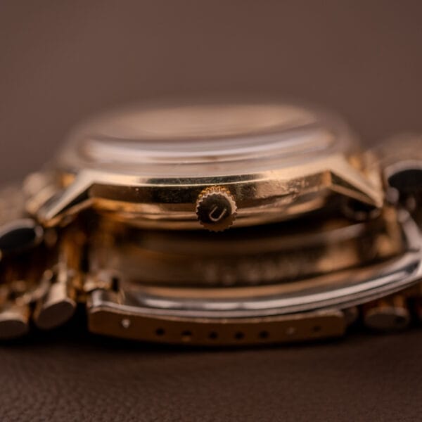 Close-up of a Universal Geneve Polerouter Date Arabic Numerals Dial Automatic Cal 215 watch lying on its side, highlighting the crown and bracelet.