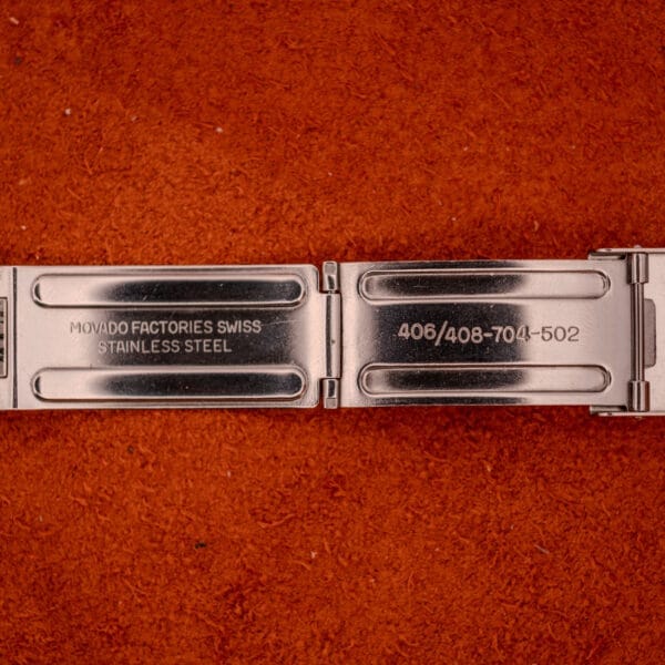 Close-up of the Movado Automatic 431 Ref. 11201's stainless steel clasp, engraved with its reference and "MOVADO FACTORIES SWISS," highlighting the precision of this stainless steel case & bracelet timepiece.