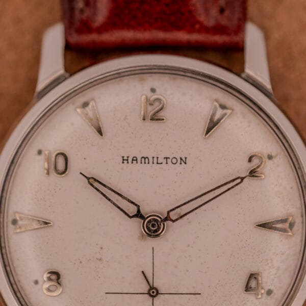 Close-up of a Hamilton Sea-Crest Stainless Steel Case & White Dial Cal. 673 wristwatch with a brown leather strap and vintage charm.