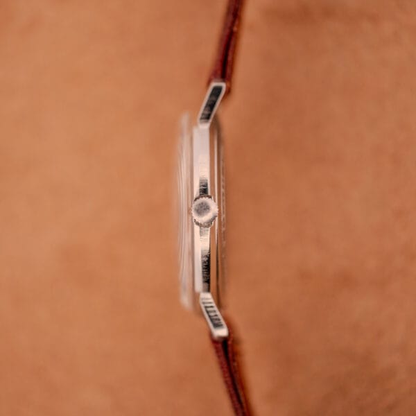 Side view of the Hamilton Sea-Crest Stainless Steel Case & White Dial Cal. 673 wristwatch with a brown leather strap, displayed against a tan background.