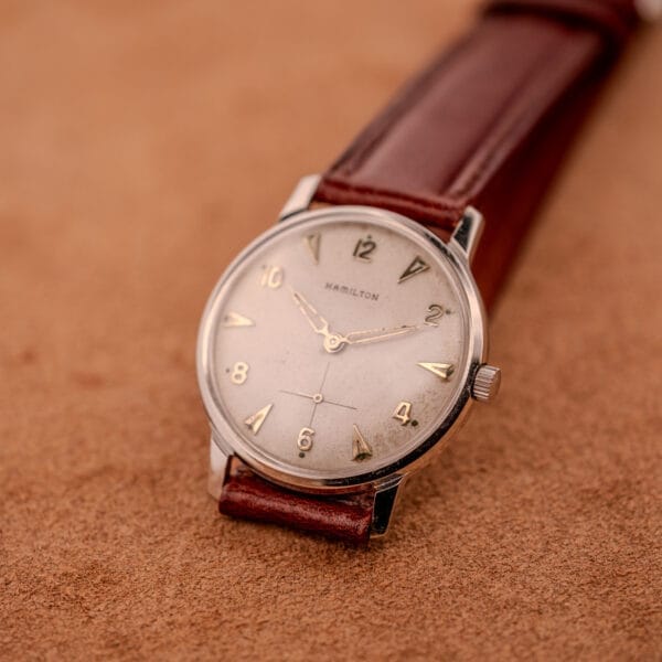 A Hamilton Sea-Crest with a stainless steel case and white dial Cal. 673 is displayed on a tan suede surface.