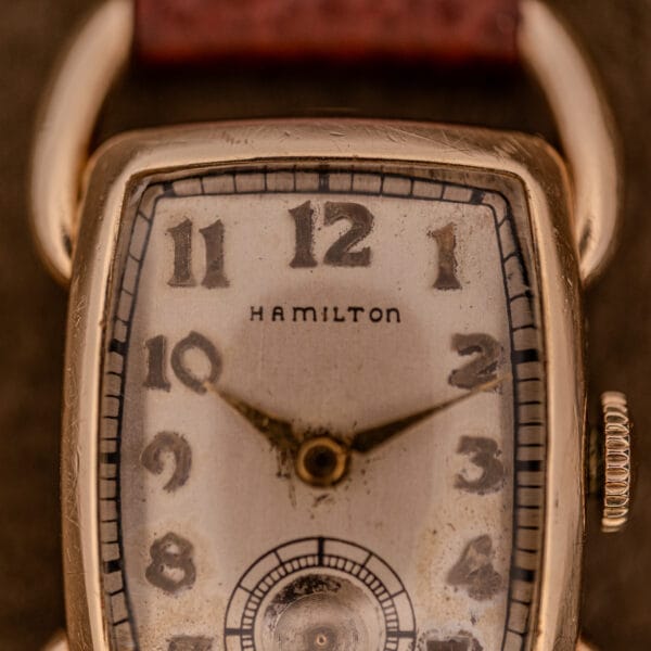 Close-up of a Hamilton Bowman Art Deco wristwatch, showcasing its 10k gold filled case and manual wind Cal. 980 movement, with vintage details and original dial.