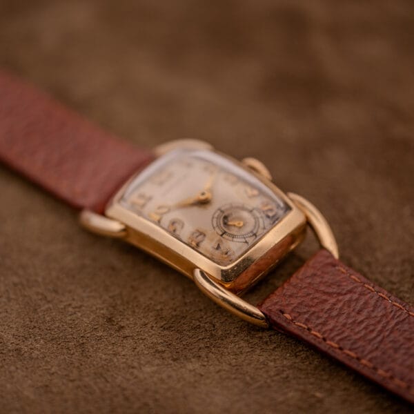 The Hamilton Bowman Art Deco watch features a manual wind Cal. 980 movement, a 10k gold filled case, and rests on a brown leather strap, capturing classic vintage style.