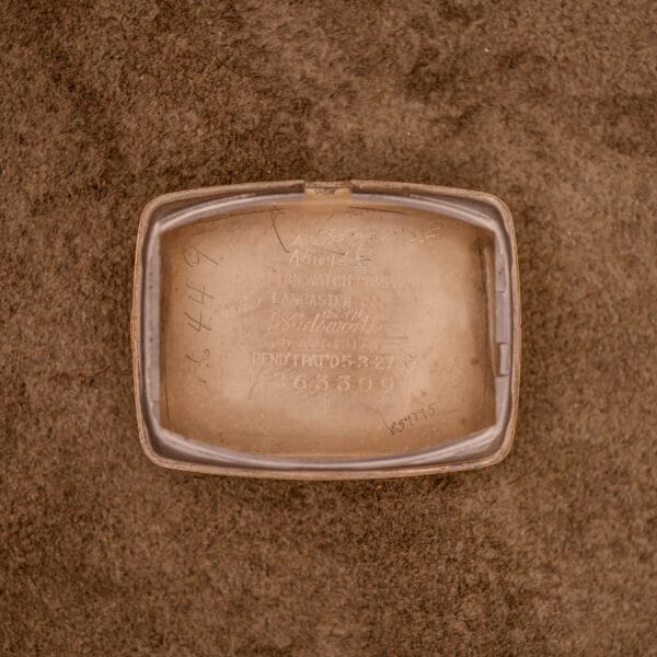 Open Hamilton Bowman Art Deco 10k gold filled case with manual wind Cal. 980, featuring engraved and handwritten numbers on a brown textured surface, highlighting its classic vintage style.