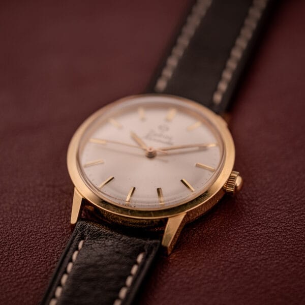 Zodiac Hermetic Ref. 673 853 wristwatch with a sunburst dial and black leather strap, shown on a brown surface. Includes original box and papers.