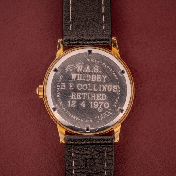 A Zodiac Hermetic Ref. 673 853 watch with a sunburst dial and black leather band, engraved for B.E. Collings’ 1970 retirement. Includes original box and papers.