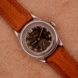 Mido Multifort Super-Automatic dial close-up showing granular black surface, luminous Arabic numerals, and red 24-hour inner track.