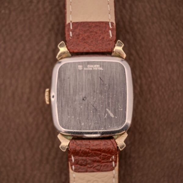 The back of the Gruen Veri-Thin Ref. 415-810 with Art Deco lugs, brown leather strap, and a scratched metal case captures classic vintage charm.