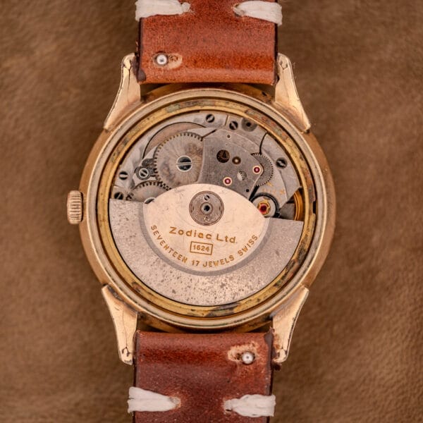 Close-up of a vintage Zodiac Hermetic Black Dial Automatic Caliber 1624 Gold Filled Case watch, showing its Swiss movement and leather strap.