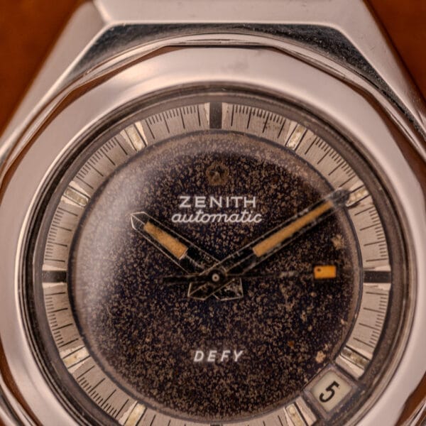 Close-up of a Zenith Automatic Defy NA.50.012.2 in stainless steel, Cal. 2562 PC, featuring a worn speckled dial and a date window at 4 o’clock.