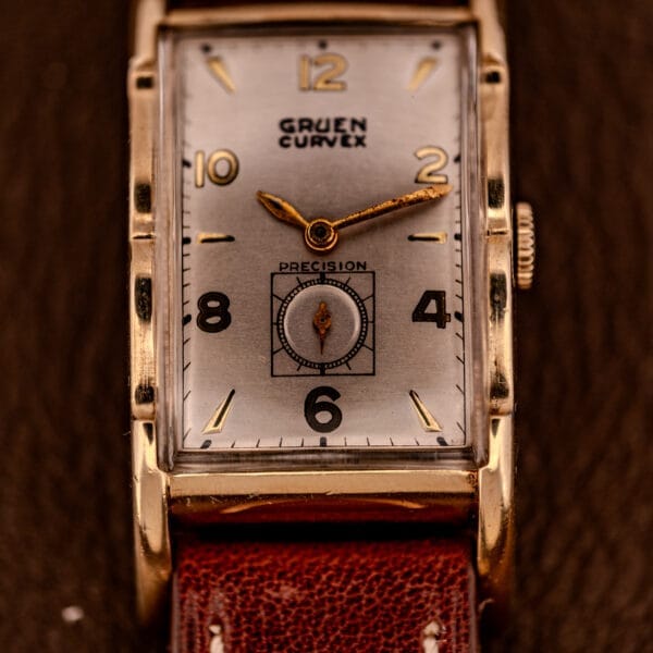 Close-up of a Gruen Curvex Precision Ref. 370-600 wristwatch with a 10k Gold Filled rectangular case and brown leather strap, showcasing classic style and craftsmanship.