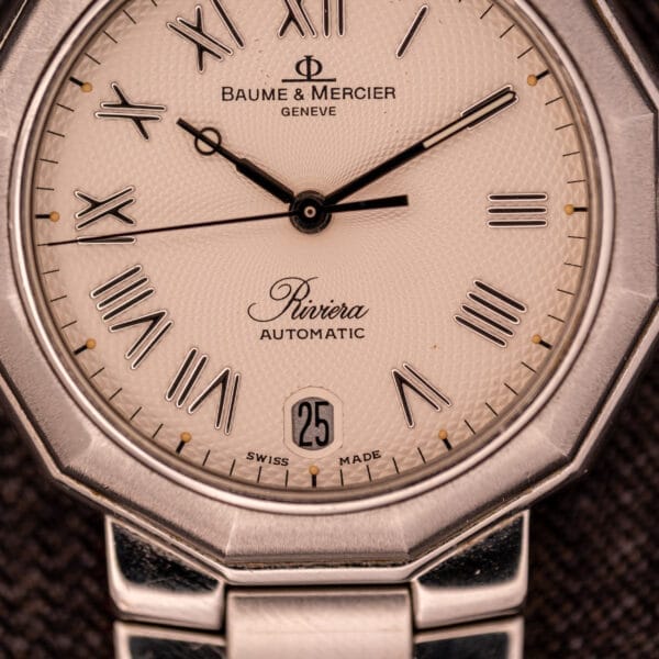 Close-up of the Baume Mercier Riviera Automatic MV045165, showcasing its Guilloché dial with Roman numerals and a date window at 6 o’clock.