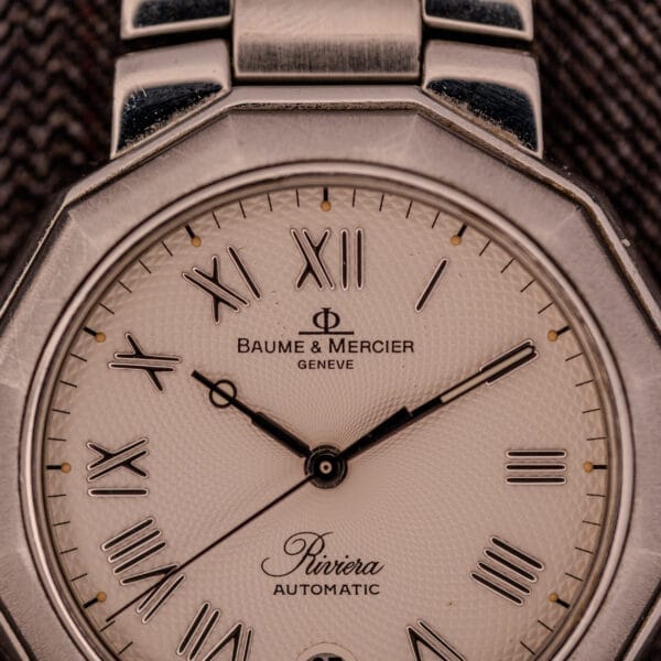 Close-up of the Baume Mercier Riviera Automatic MV045165 with Roman numerals, metal strap, and a detailed guilloché dial.