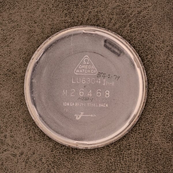 Omega Automatic Ref. LU 6304 "HF" Logo Dial features a round case back with engraved model and serial numbers on a textured brown surface, perfectly complementing the classic 10k GF Bezel.