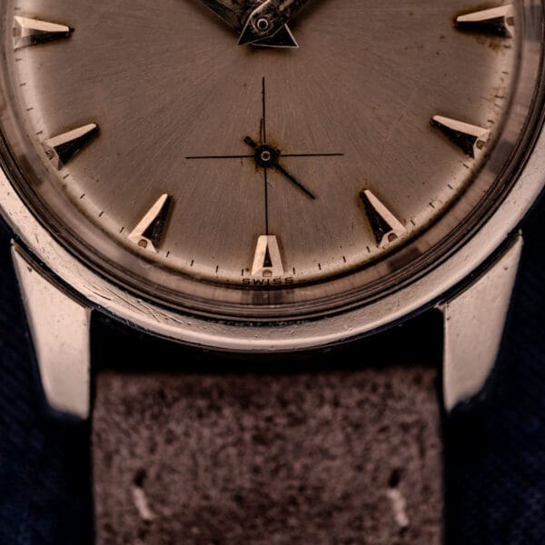 Close-up of an Omega Automatic Seamaster 2846-2848 wristwatch with a stainless steel sunburst dial and a worn brown leather strap.